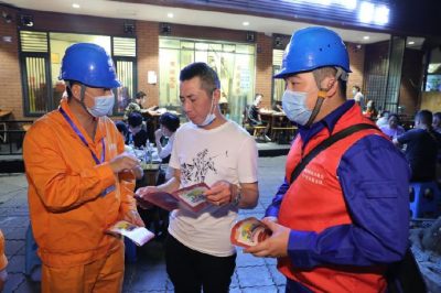 為各個攤位檢查用電安全情況、排查隱患、發(fā)放用電安全宣傳單